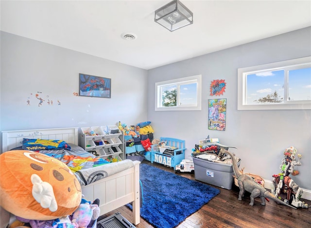 bedroom with visible vents and wood finished floors