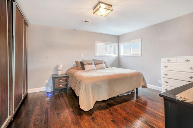 bedroom featuring dark wood-style floors, visible vents, and baseboards