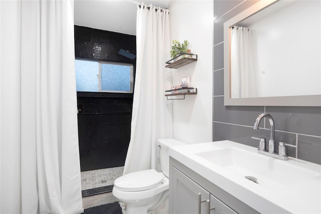 bathroom featuring toilet, a tile shower, and vanity