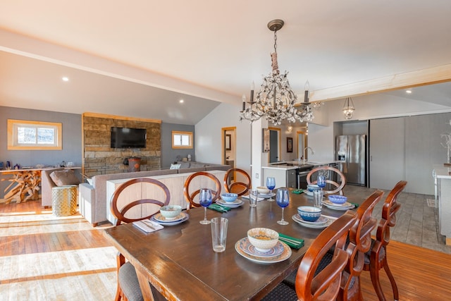 dining room featuring recessed lighting, a notable chandelier, vaulted ceiling with beams, and light wood finished floors