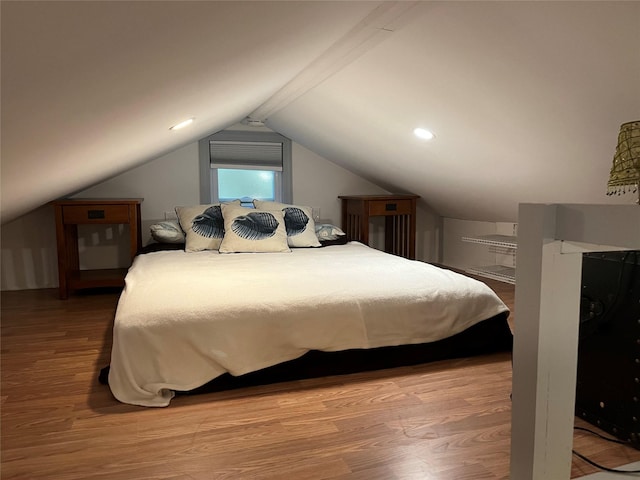 bedroom featuring vaulted ceiling with beams and wood finished floors