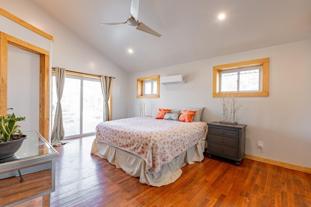 bedroom with access to exterior, an AC wall unit, multiple windows, and wood finished floors