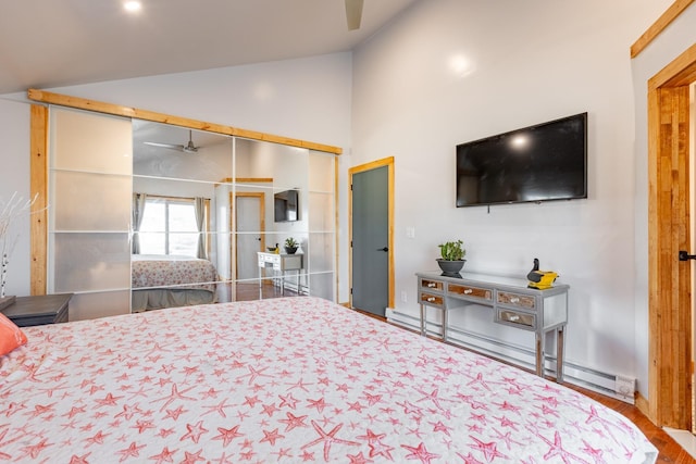 bedroom featuring a baseboard heating unit and high vaulted ceiling