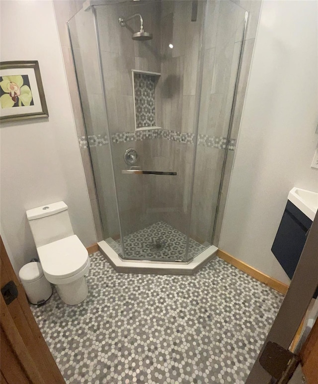 full bath featuring vanity, a shower stall, toilet, and baseboards