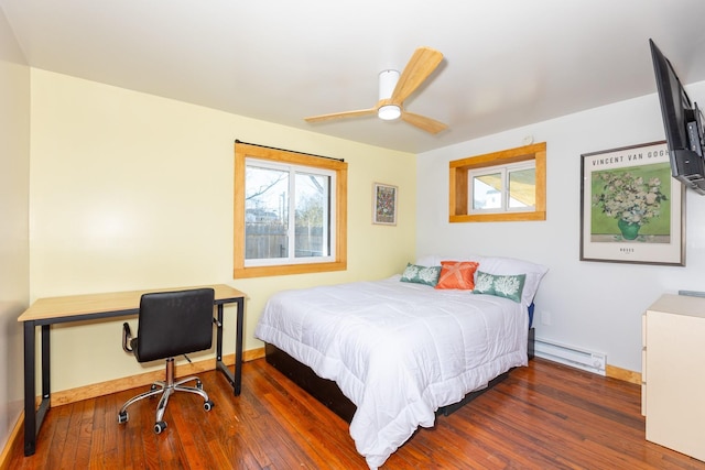 bedroom with a baseboard radiator, baseboards, multiple windows, and hardwood / wood-style floors