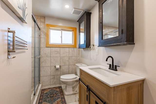 bathroom with a stall shower, visible vents, vanity, and toilet