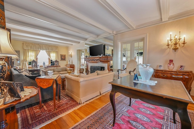 living area with ornamental molding, a fireplace, beamed ceiling, and wood finished floors