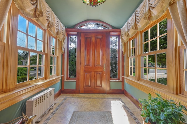 foyer featuring marble finish floor, radiator heating unit, baseboards, and vaulted ceiling