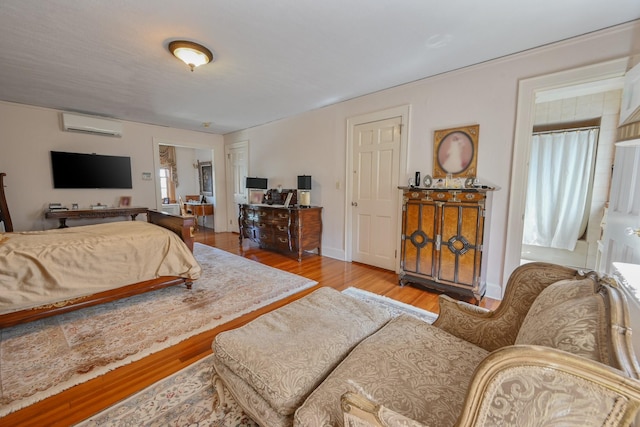 bedroom featuring a wall mounted AC and wood finished floors