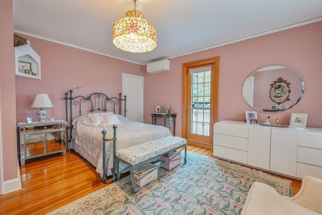 bedroom with ornamental molding, light wood-type flooring, an AC wall unit, and baseboards