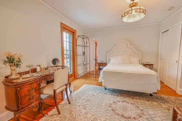 bedroom with ornamental molding and light wood-style floors