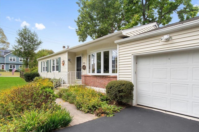 view of front of house with a garage, driveway, and brick siding