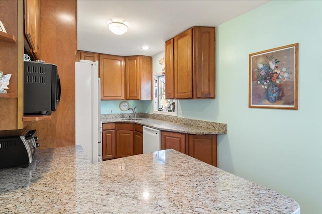 kitchen featuring white appliances, a toaster, brown cabinets, and a sink