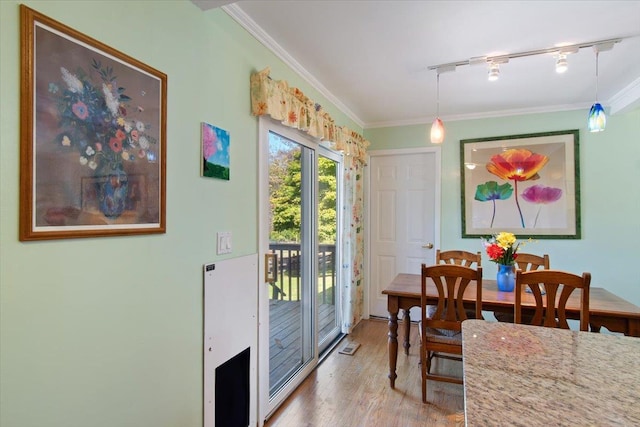 dining area with visible vents, wood finished floors, rail lighting, and crown molding