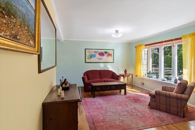 living area with crown molding, baseboards, and wood finished floors