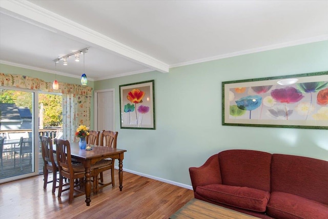 dining space featuring crown molding, baseboards, and wood finished floors