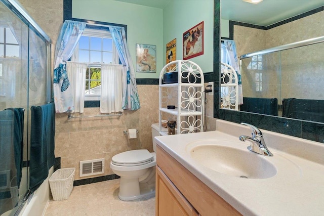 bathroom with shower / bath combination with glass door, tile walls, visible vents, toilet, and vanity