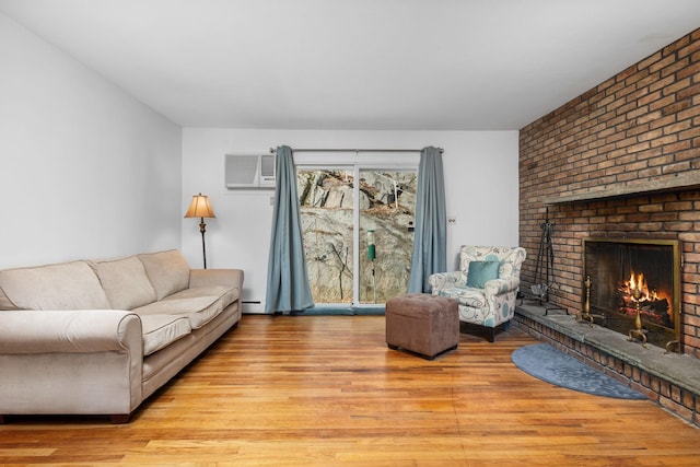 living room with a baseboard radiator, a brick fireplace, a wall mounted air conditioner, and wood finished floors