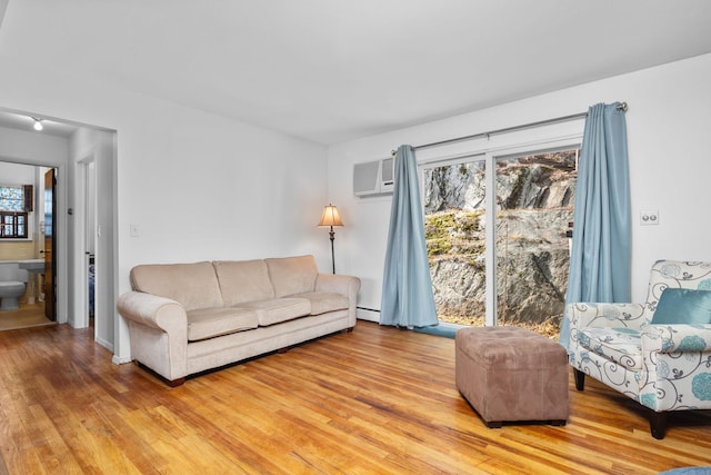 living room featuring light wood-style floors and a baseboard heating unit