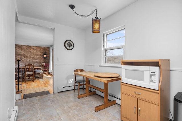 dining room featuring a wainscoted wall, brick wall, and a baseboard radiator