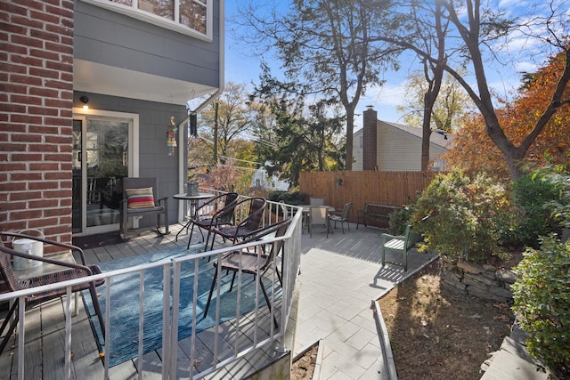 wooden terrace featuring fence, a patio, and outdoor dining space