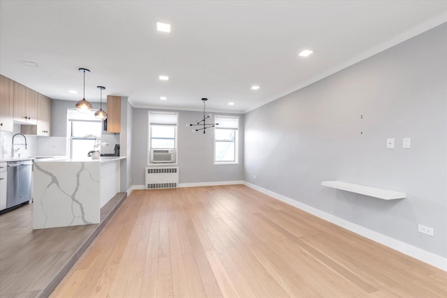 kitchen featuring baseboards, light wood-type flooring, decorative backsplash, dishwasher, and radiator heating unit