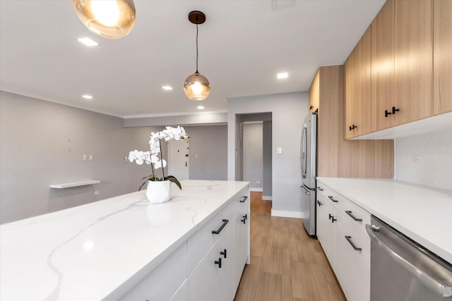 kitchen with appliances with stainless steel finishes, decorative light fixtures, baseboards, and white cabinetry