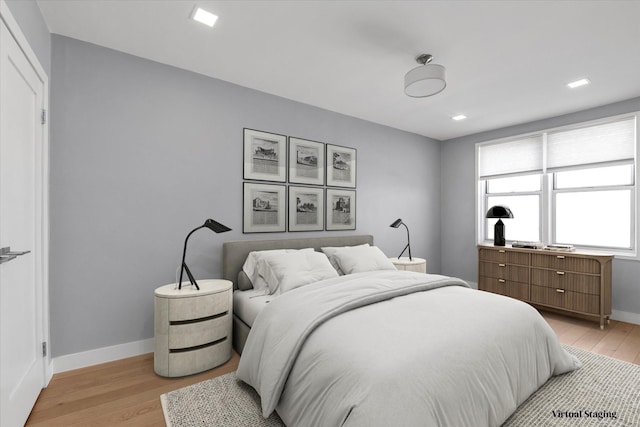 bedroom with light wood-type flooring and baseboards