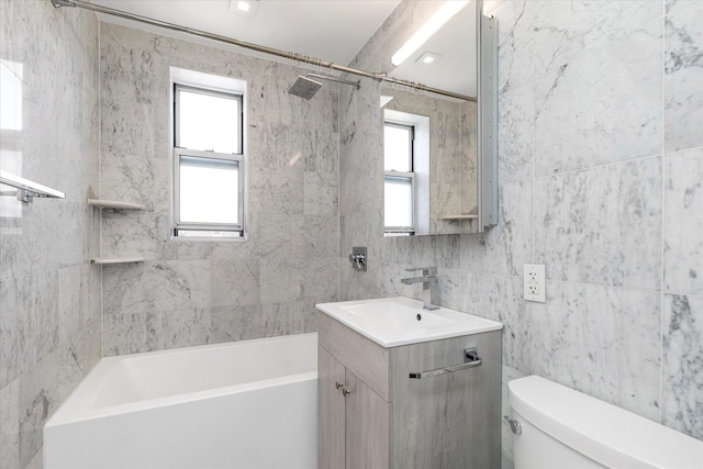 bathroom featuring a wealth of natural light, tile walls, vanity, and toilet