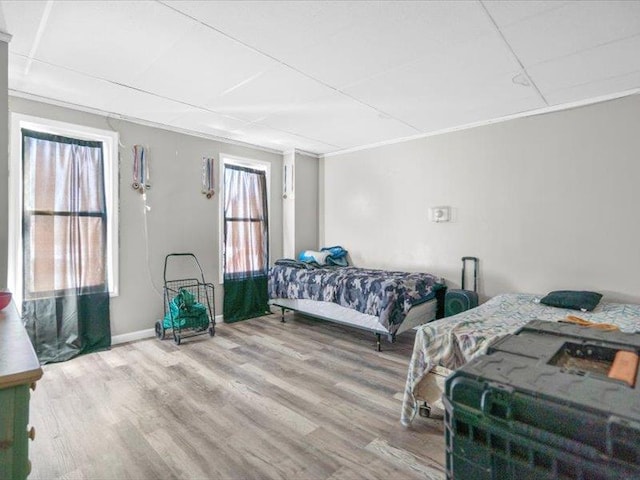 bedroom with wood finished floors and crown molding