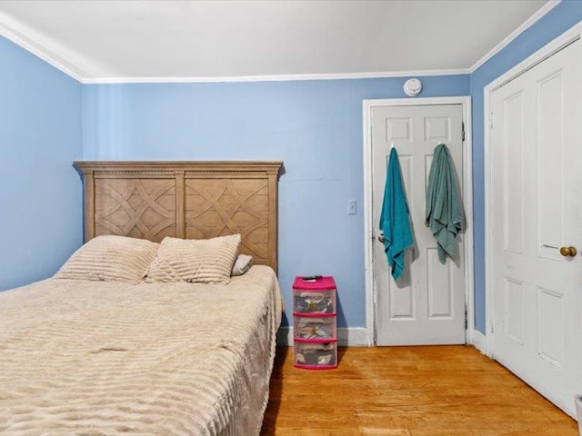 bedroom featuring crown molding and wood finished floors