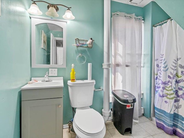 bathroom with toilet, curtained shower, vanity, and tile patterned floors