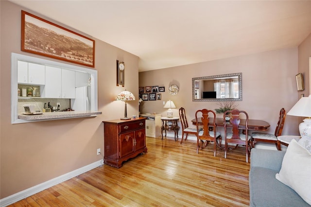 living area with light wood-style flooring and baseboards