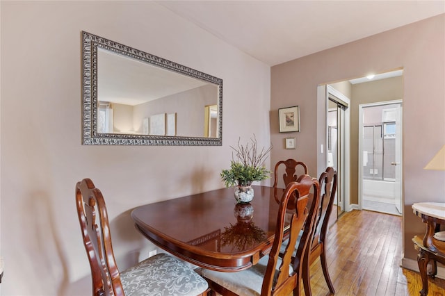 dining room featuring hardwood / wood-style flooring and baseboards