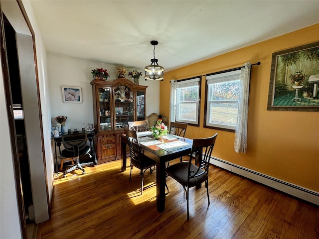dining room featuring wood finished floors and baseboard heating