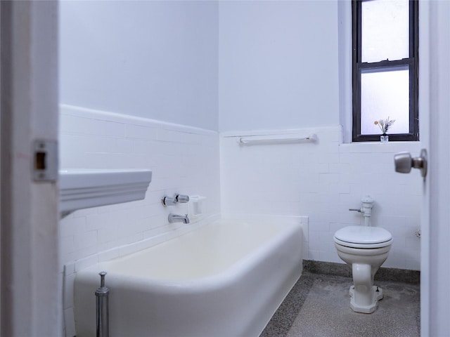 full bath featuring toilet, a wainscoted wall, tile walls, and a bath