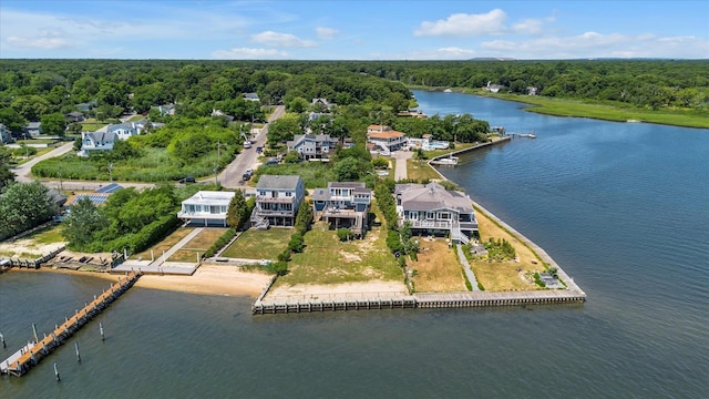 birds eye view of property featuring a water view and a wooded view