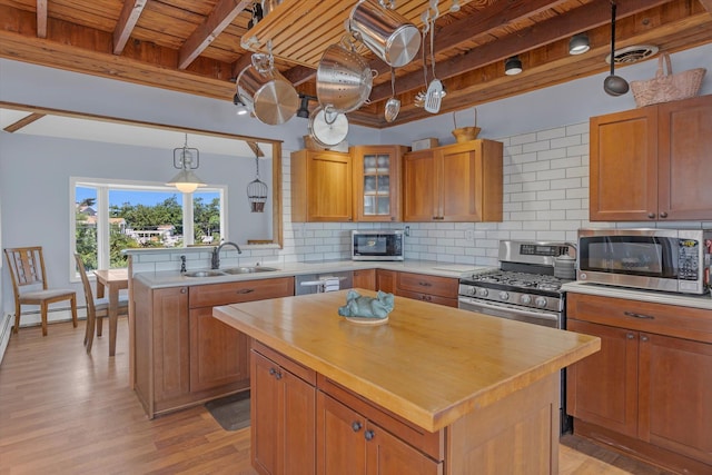 kitchen featuring stainless steel appliances, wood counters, a sink, visible vents, and backsplash