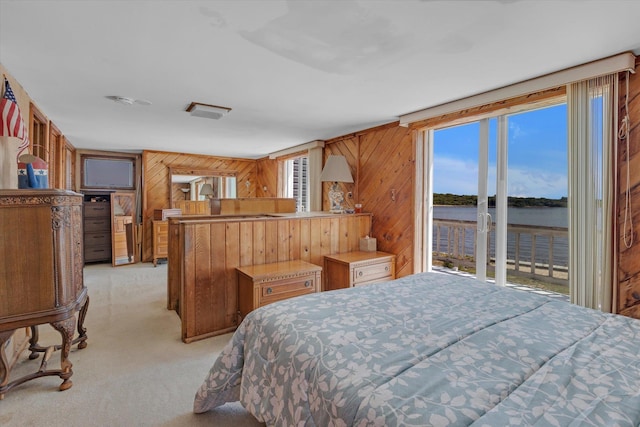 bedroom with light carpet and wooden walls