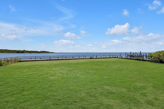 view of yard with a water view and fence