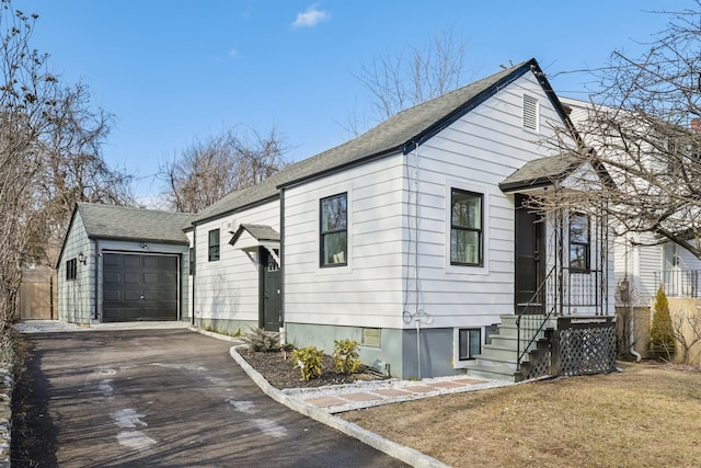 view of front of property featuring an attached garage, driveway, and an outdoor structure