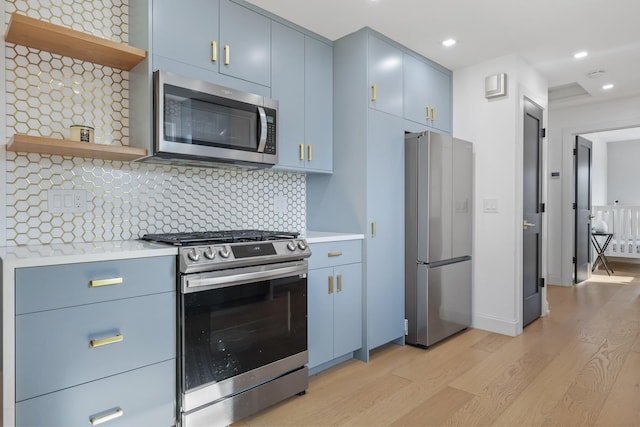 kitchen with open shelves, blue cabinetry, stainless steel appliances, and light countertops