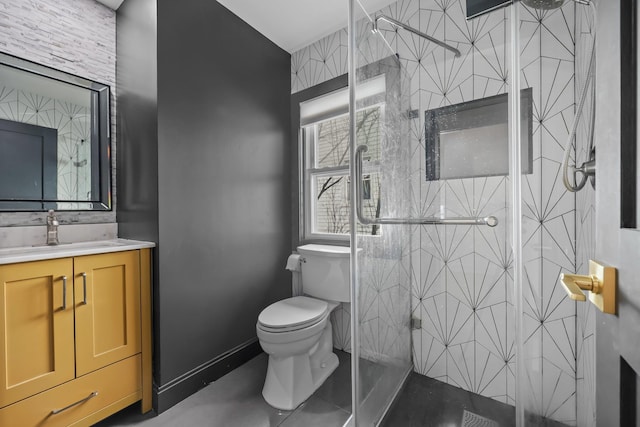 full bath featuring toilet, a stall shower, baseboards, and vanity