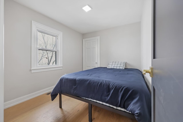 bedroom with baseboards and wood finished floors
