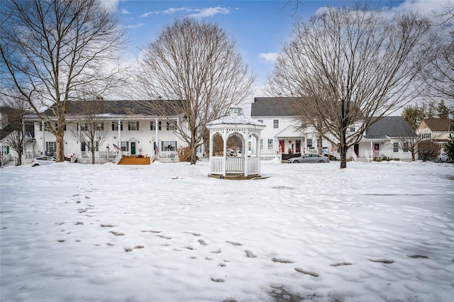 snow covered rear of property featuring a gazebo