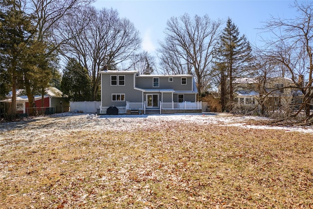 back of property featuring a porch and fence