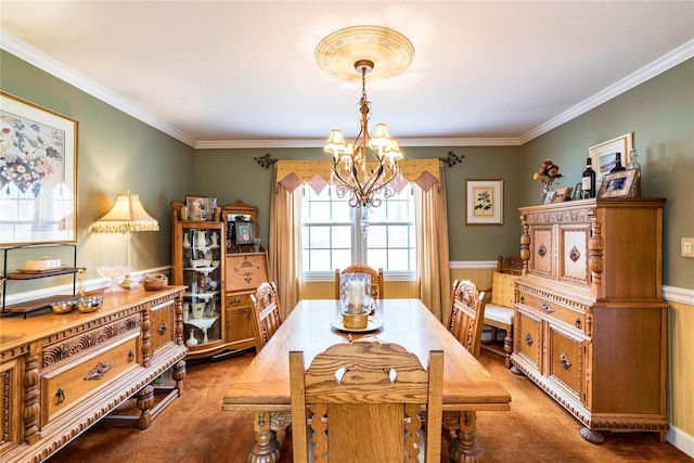 dining room featuring carpet floors, crown molding, a notable chandelier, and wainscoting