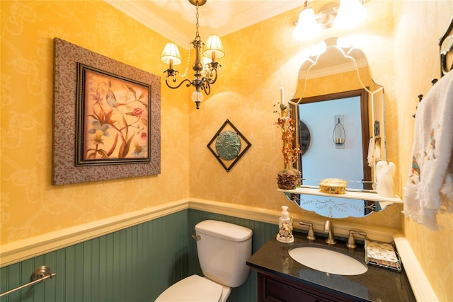 bathroom featuring toilet, a wainscoted wall, vanity, wallpapered walls, and an inviting chandelier