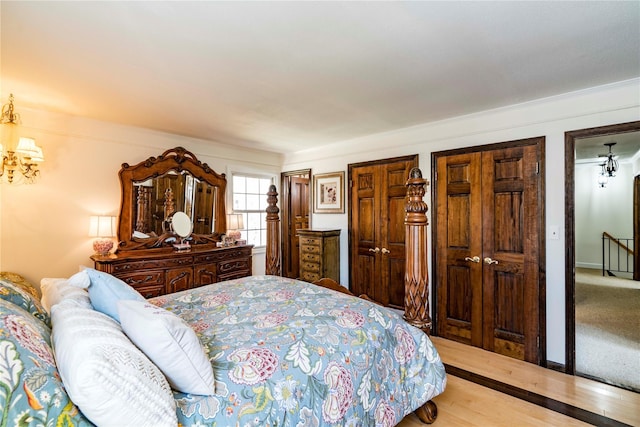 bedroom featuring baseboards, light wood-style floors, and multiple closets