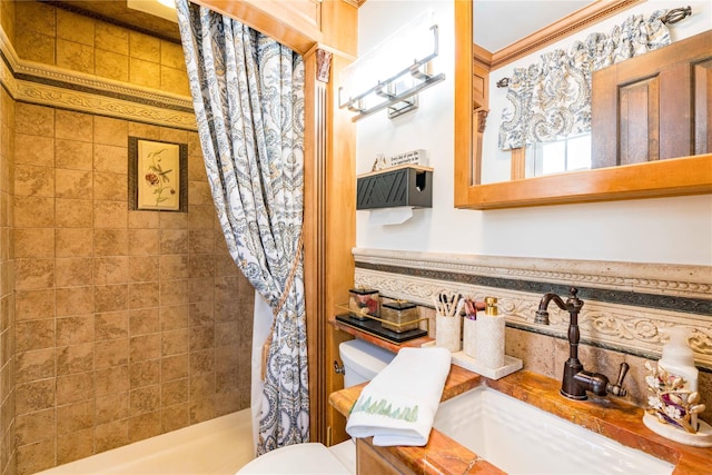 bathroom with tiled shower, a sink, and toilet